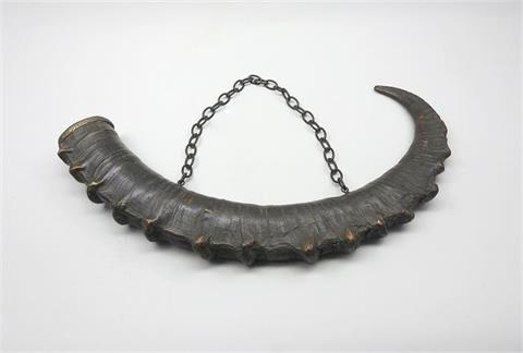Verziertes Horn eines Steinbocks mit Kette